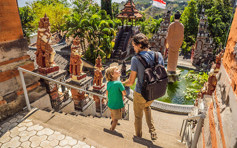 Father and son walking down stairs of Bali temple